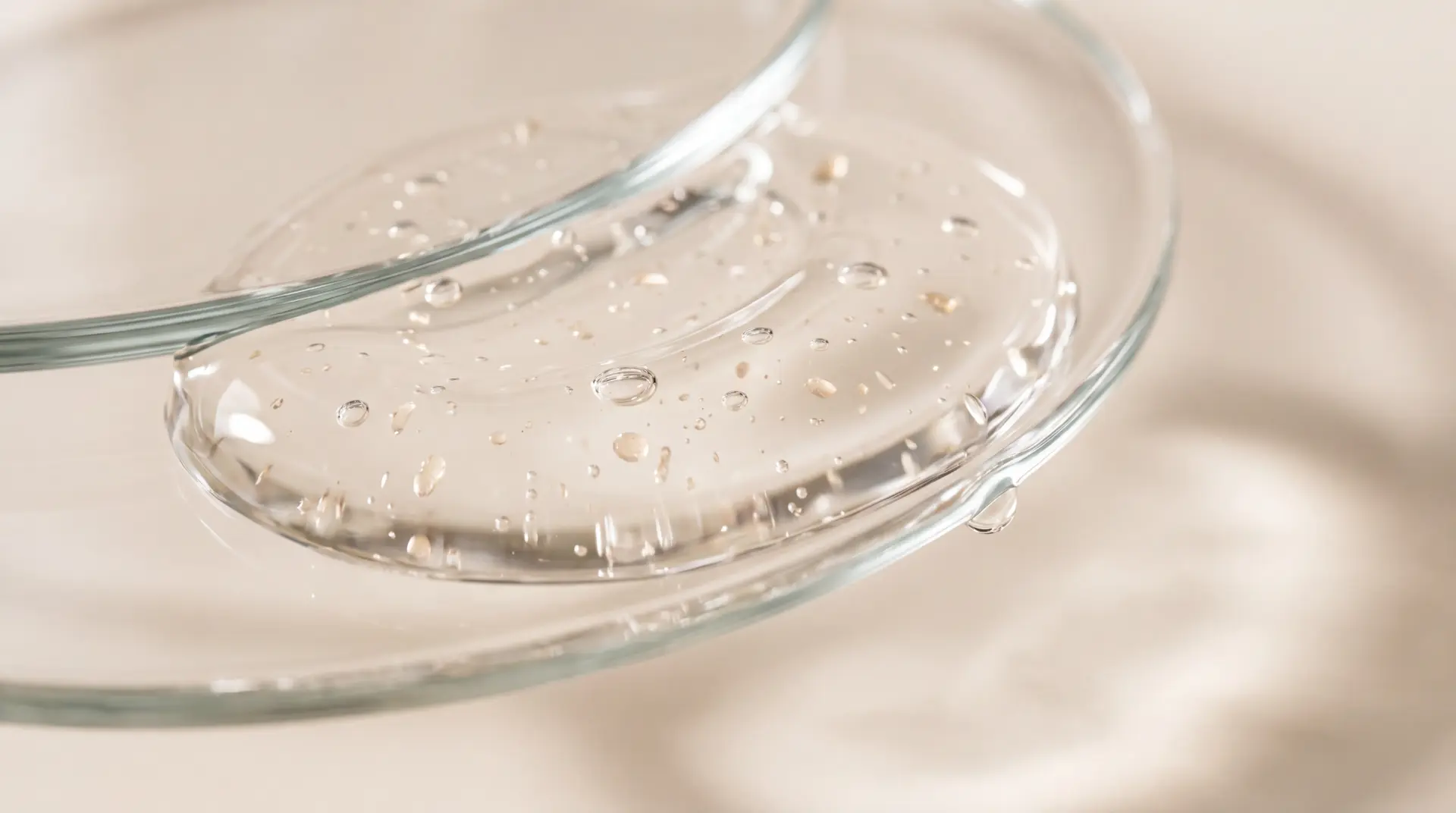 Macro close-up of the Munèa hydrogel eye patches with moisture droplets on glass